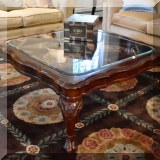 F10. Footed beveled glass top coffee table. 17”h x 41”w 
